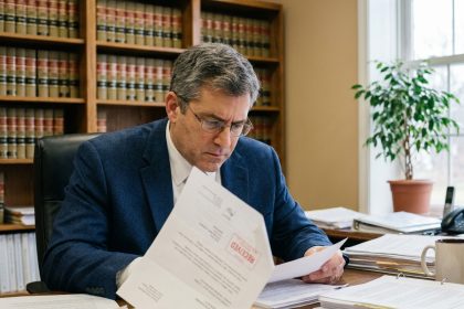 Homme en costume consultant des documents administratifs liés à un recours contre une décision de permis de construire